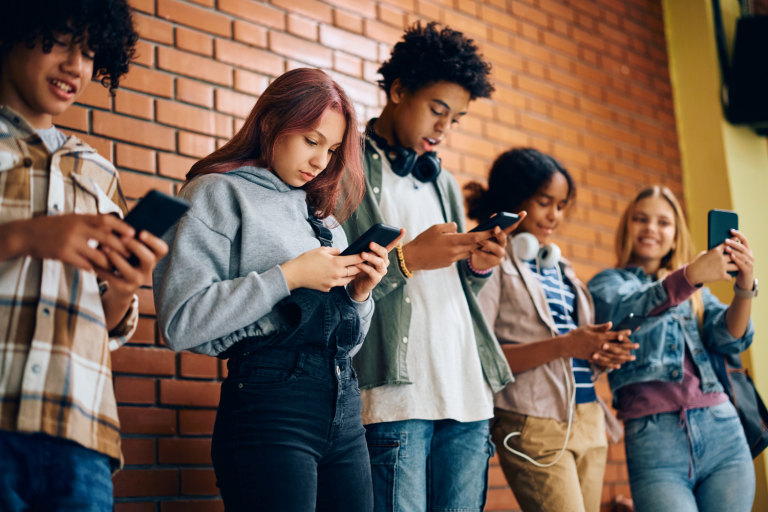 Adolescentes usando celular na escola