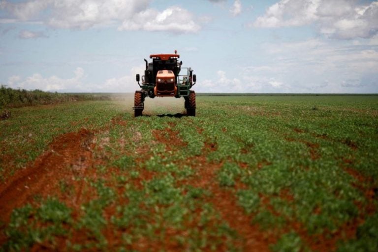 Agricultor dirigindo trator com fertilizante