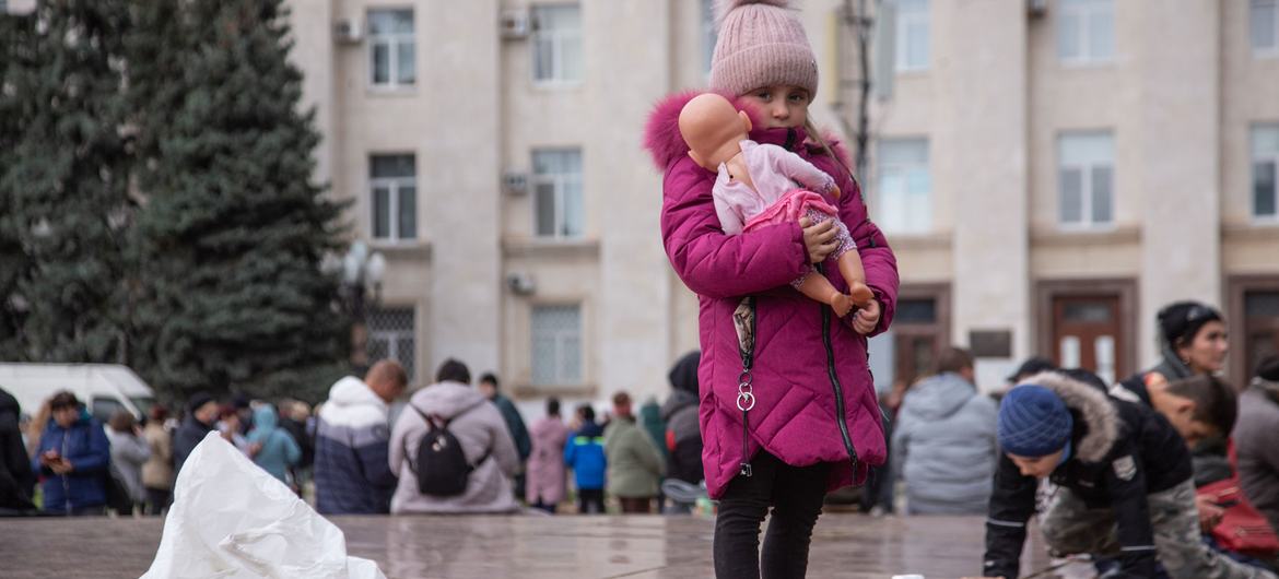 Uma menina segura sua boneca na praça central de Kherson, na Ucrânia.