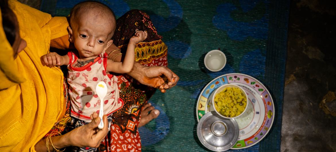 Uma criança desnutrida é alimentada em um abrigo em um assentamento de refugiados em Cox's Bazar, Bangladesh