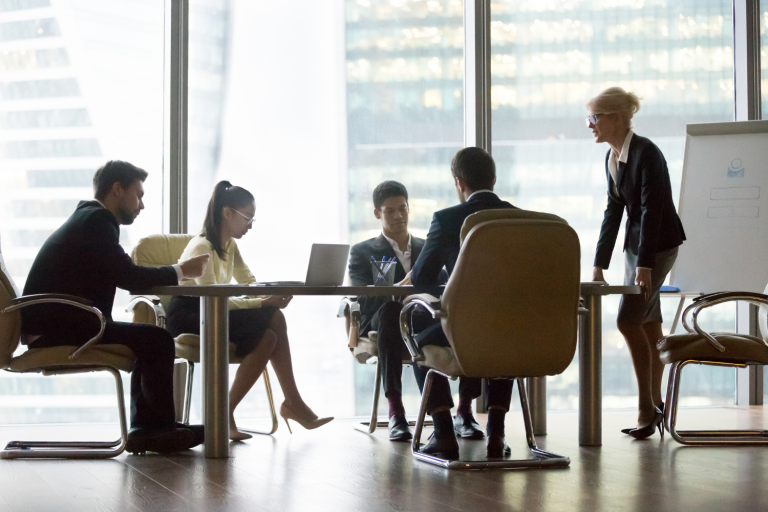 Ambiente corporativo com pessoas escutando uma líder