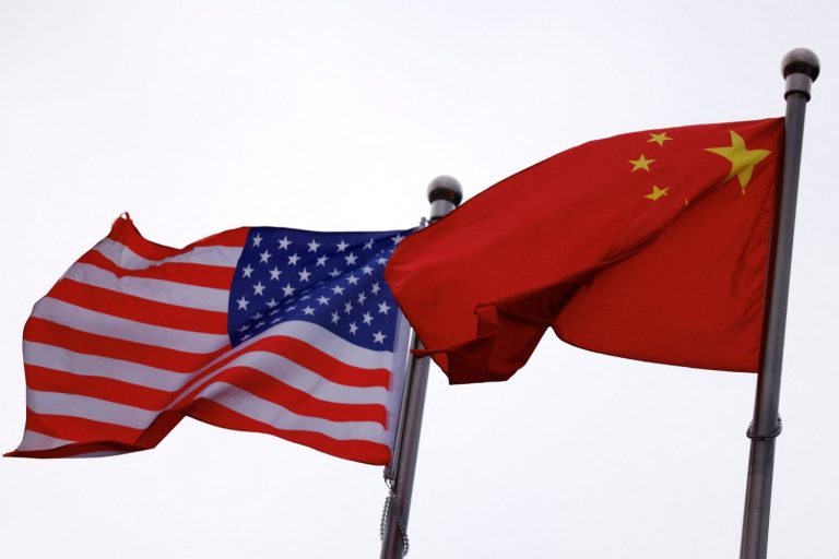 Bandeiras dos EUA e da China em edifício de empresa norte-americana em Pequim