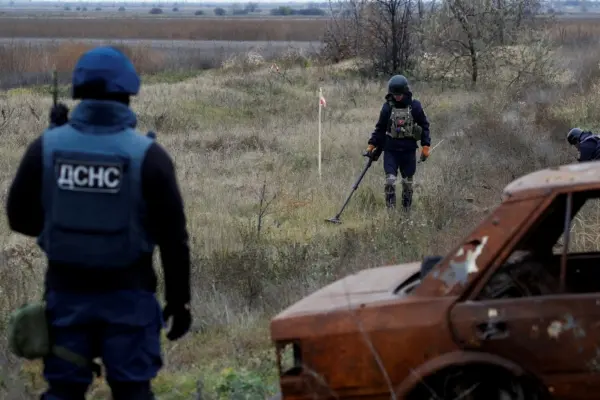 Especialistas em minas ucranianos procuram munições e minas terrestres não explodidas pela estrada principal para Kherson, Ucrânia, em 16 de novembro de 2022.