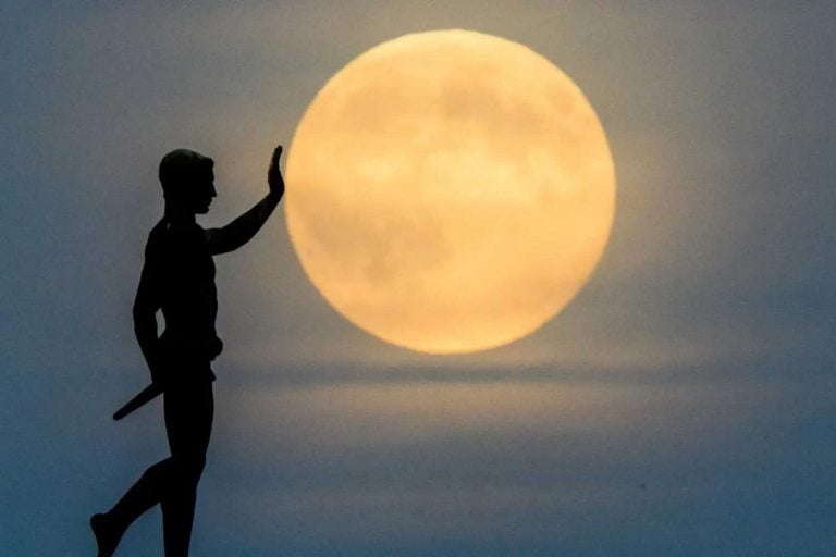 A lua nasce no horizonte atrás da estátua “Portador da Tocha” (1937), na margem norte do lago Maschsee. À noite, a maior lua cheia do ano pode ser vista sobre a Alemanha.