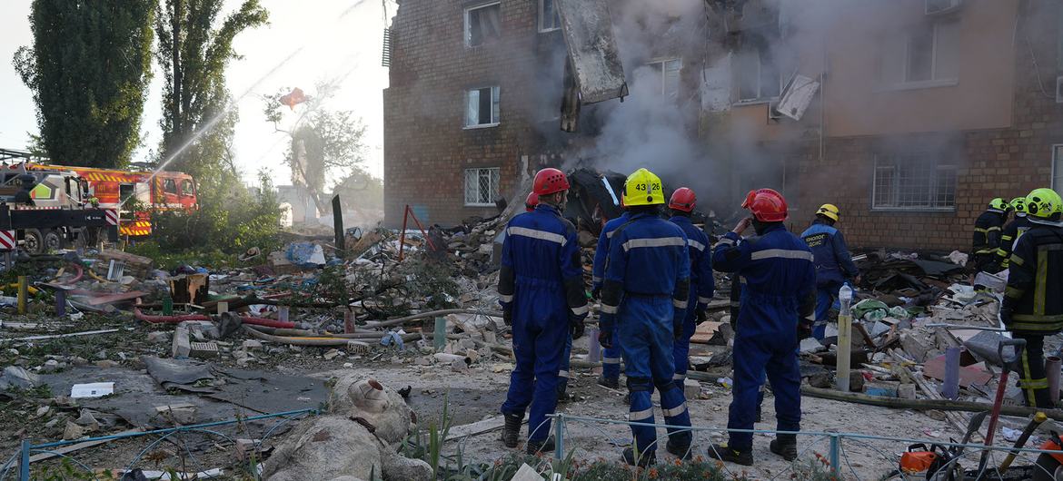 Bombeiros trabalham entre os escombros de um prédio residencial em Kiev